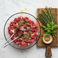 Grass-fed ground beef with seasonings ready to cook